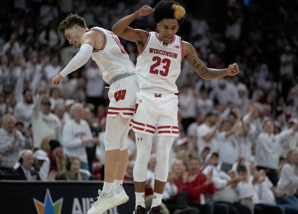 Wisconsin guard Max Klesmit, left, celebrates a three-point basket with guard Chucky Hepburn against Marquette during the first half at the Kohl Center in Madison.