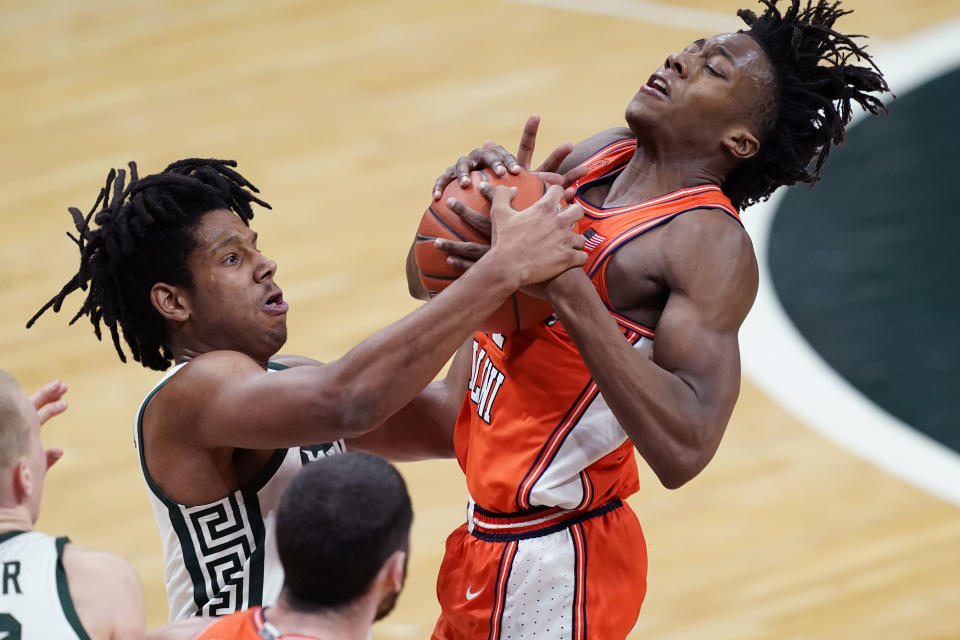 Michigan State guard A.J. Hoggard, left, and Illinois guard Ayo Dosunmu fight for control of the ball during the first half of an NCAA college basketball game, Tuesday, Feb. 23, 2021, in East Lansing, Mich. (AP Photo/Carlos Osorio)