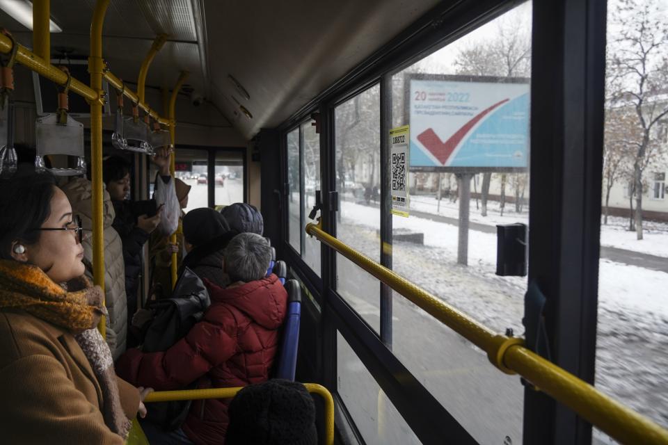 An election poster, in the background, is seen through a bus window in Almaty, Kazakhstan, Thursday, Nov. 17, 2022. Kazakhstan's president, who faced a bloody outburst of unrest early this year and then moved to marginalize some of the Central Asian country's longtime powerful figures, appears certain to win a new term against little-known challengers in a snap election on Sunday. (Vladimir Tretyakov/NUR.KZ via AP)