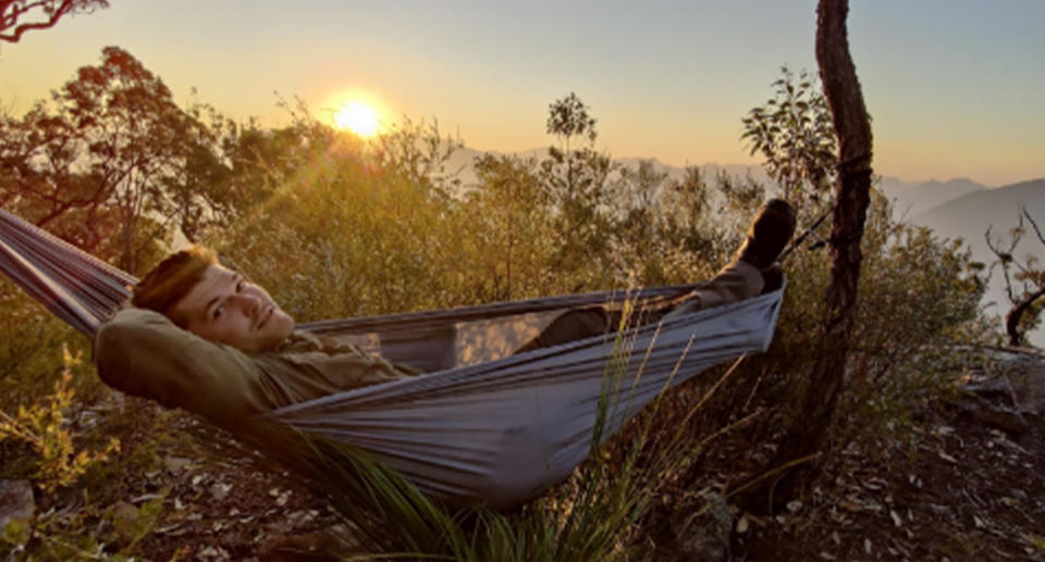 Benjamin Goode in a hammock watching the sunset. 