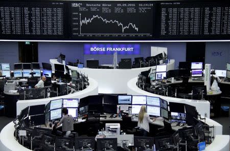 Traders work at their desks in front of the German share price index, DAX board, at the stock exchange in Frankfurt, Germany, September 9, 2016. REUTERS/Staff/Remote