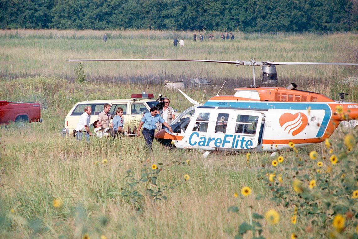 Aug. 31, 1988: Paramedics rush a conscious crash victim from Delta 1141 to a rescue CareFlite helicopter while a television reporter captures the scene. The plane crashed during takeoff at Dallas-Fort Worth International Airport.