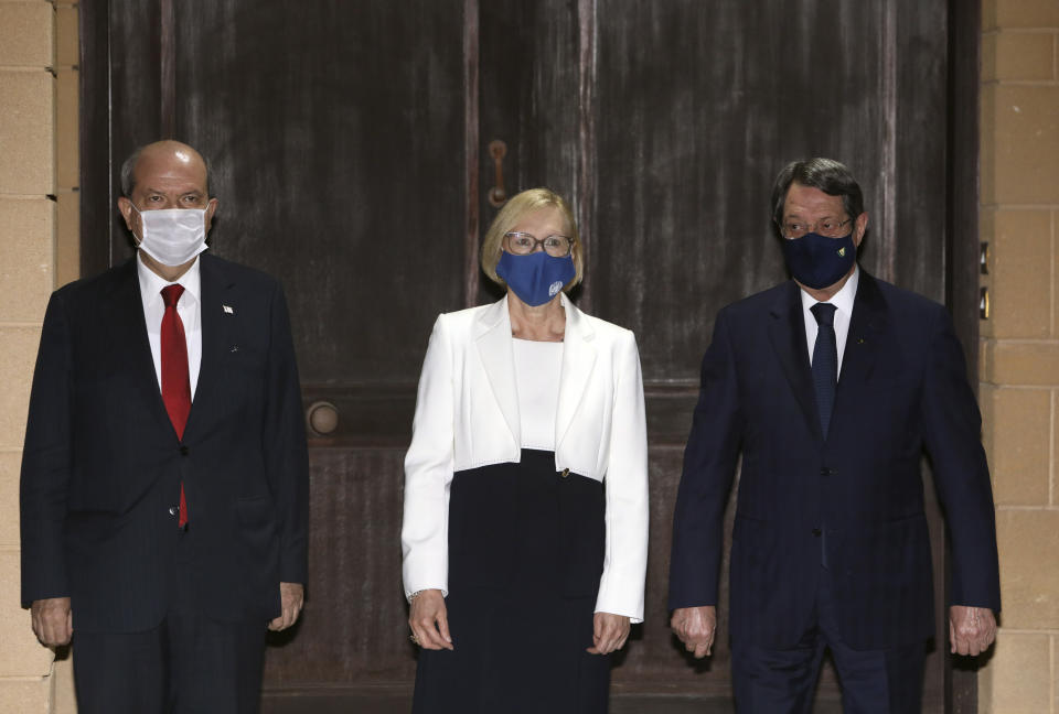 Turkish Cypriot leader Ersin Tatar, left, Elizabeth Spehar, center, head of the United Nations Peace Keeping Force in Cyprus and Nicos Anastasiades, the Greek Cypriot President of war-divided Cyprus, stand in front of Spehar's official residence before their talks inside the U.N.-controlled buffer zone separating the breakaway Turkish Cypriot north from the internationally recognized Greek Cypriot south in the capital Nicosia, Cyprus, on Tuesday, Nov. 3, 2020. Anastasiades and Tatar held their first informal face-to-face meeting hosted by Spehar following Tatar's election as Turkish Cypriot leader last month amid hopes of a possible resumption of dormant reunification talks. (Katia Christodoulou Pool via AP)