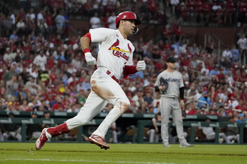 St. Louis Cardinals' Dylan Carlson, left, hits a ground-rule double off Miami Marlins starting pitcher Braxton Garrett, right, to score Tommy Edman during the fifth inning of a baseball game Tuesday, June 28, 2022, in St. Louis. (AP Photo/Jeff Roberson)