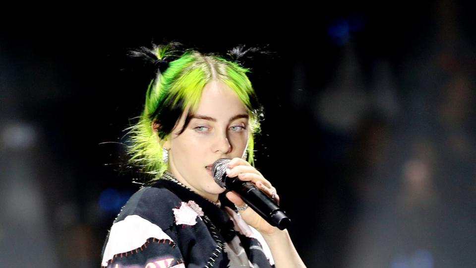 billie eilish with green hair, on stage performing