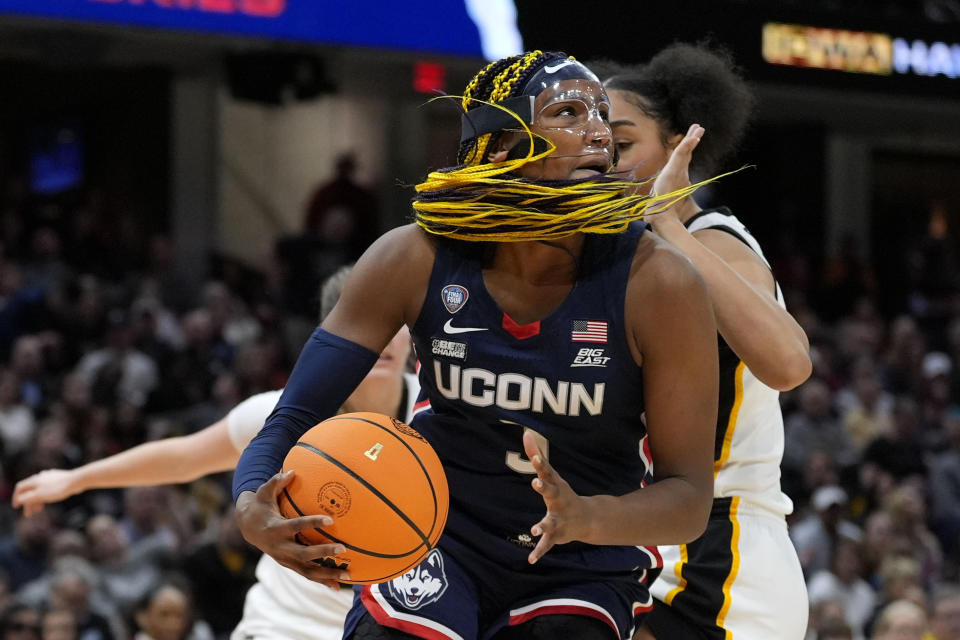 UConn forward Aaliyah Edwards drives to the basket in front of Iowa forward Hannah Stuelke, rear, during the first half of a Final Four college basketball game in the women's NCAA Tournament, Friday, April 5, 2024, in Cleveland. (AP Photo/Morry Gash)