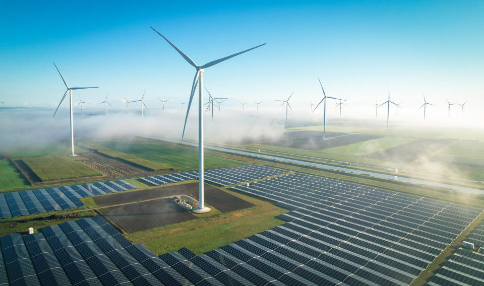 Solar energy fields and wind turbines seen from the air in foggy conditions during a Autumn morning. Muntendam, the Netherlands, September 2022