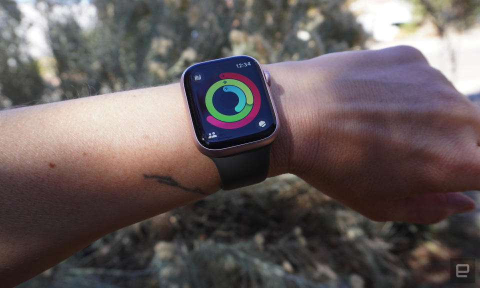 Eine Person trägt die Apple Watch, auf der die Aktivitäts-App und die Fitnessringe angezeigt werden.  
