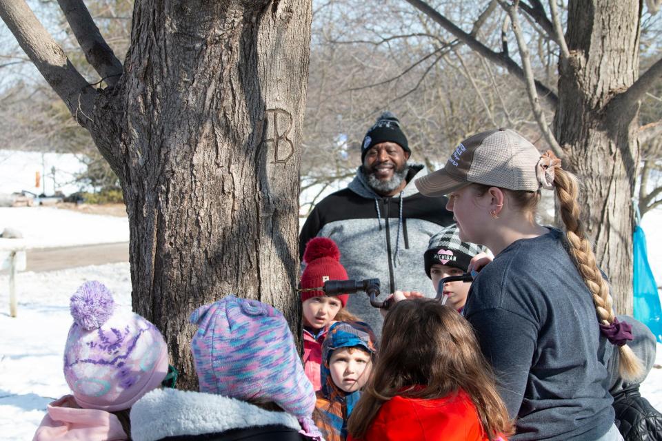 Guests at the Farmington Hills Nature Center tapping maple trees for sap.