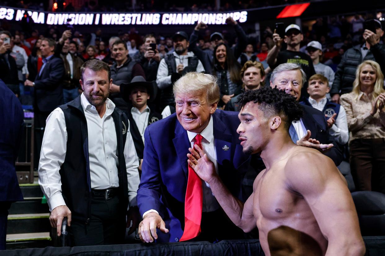 Former President Donald Trump congratulates Carter Starocci of Penn State after he won a national championship during  the NCAA Division 1 Wrestling Championships at the BOK Center Saturday, March 18, 2023 in Tulsa, Ok. At left is Senator Markwayne Mullin. 