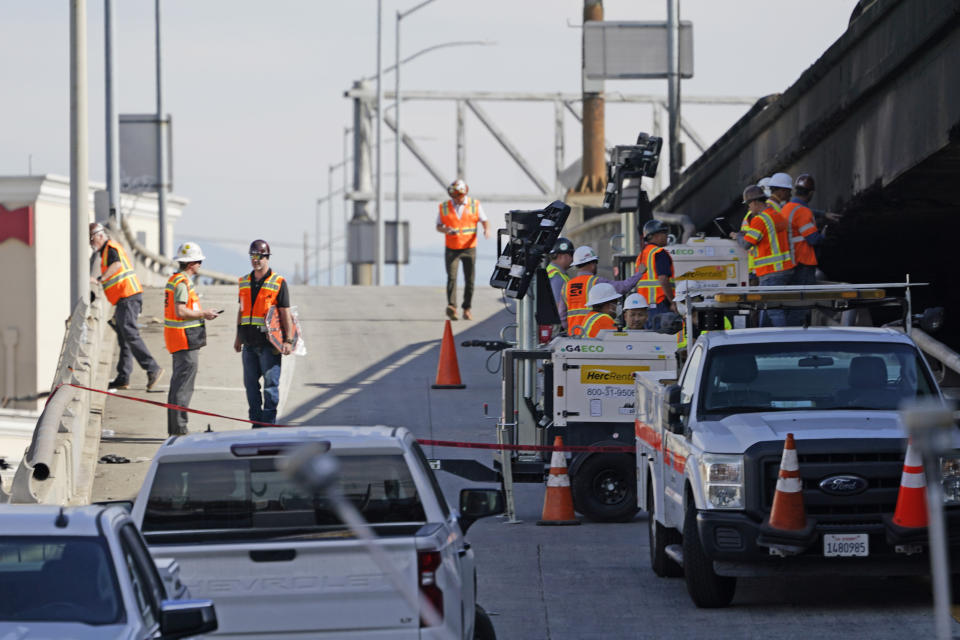 Workers clean the site of a weekend fire which caused the closure of Interstate 10 Monday, Nov. 13, 2023, in Los Angeles. Los Angeles drivers are being tested in their first commute since a weekend fire that closed a major elevated interstate near downtown. (AP Photo/Ryan Sun)