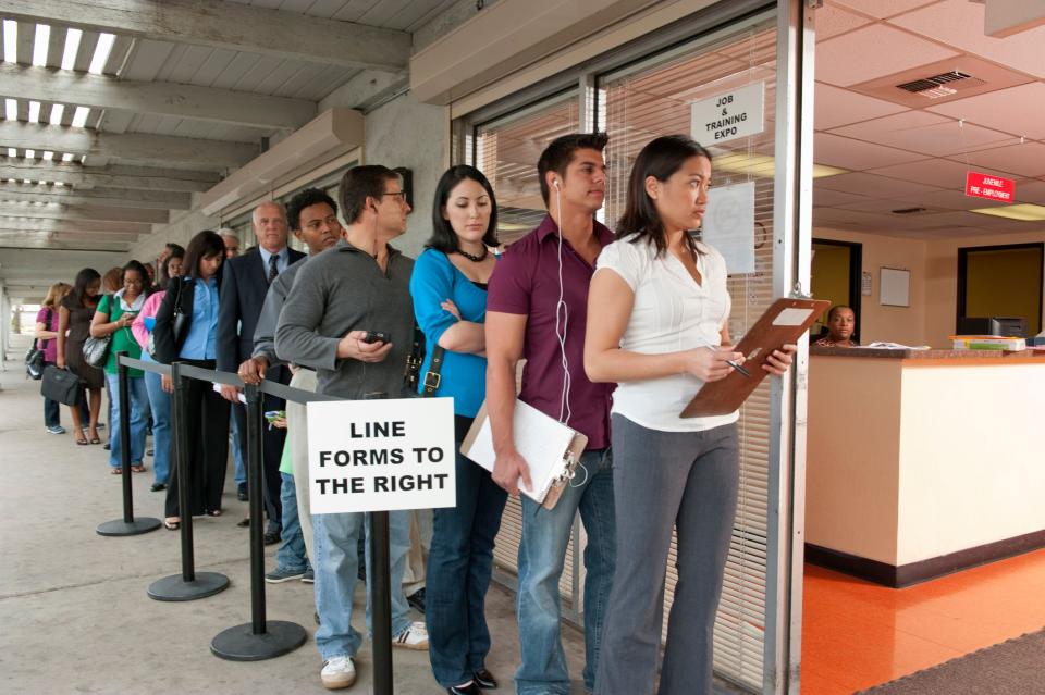 A long line of people waiting to get into an office.