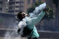 <p>Un manifestante se deshace de un contenedor de gas lacrimógeno lanzado por la policía durante los enfrentamientos con la policía antidisturbios durante un mitin en Caracas, Venezuela, 8 de abril de 2017. REUTERS / Carlos Garcia Rawlins</p>