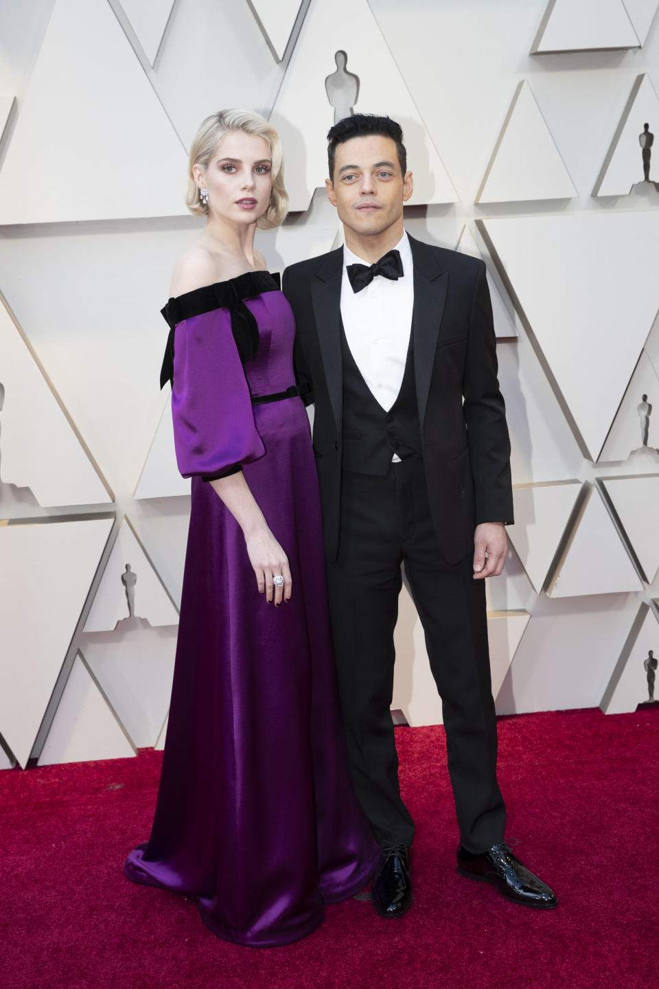 <p>The “Bohemian Rhapsody” costars and off-screen couple arrived hand-in-hand in a purple Rodarte gown and a classic tuxedo by Saint Laurent. <em>[Photo: Getty]</em> </p>