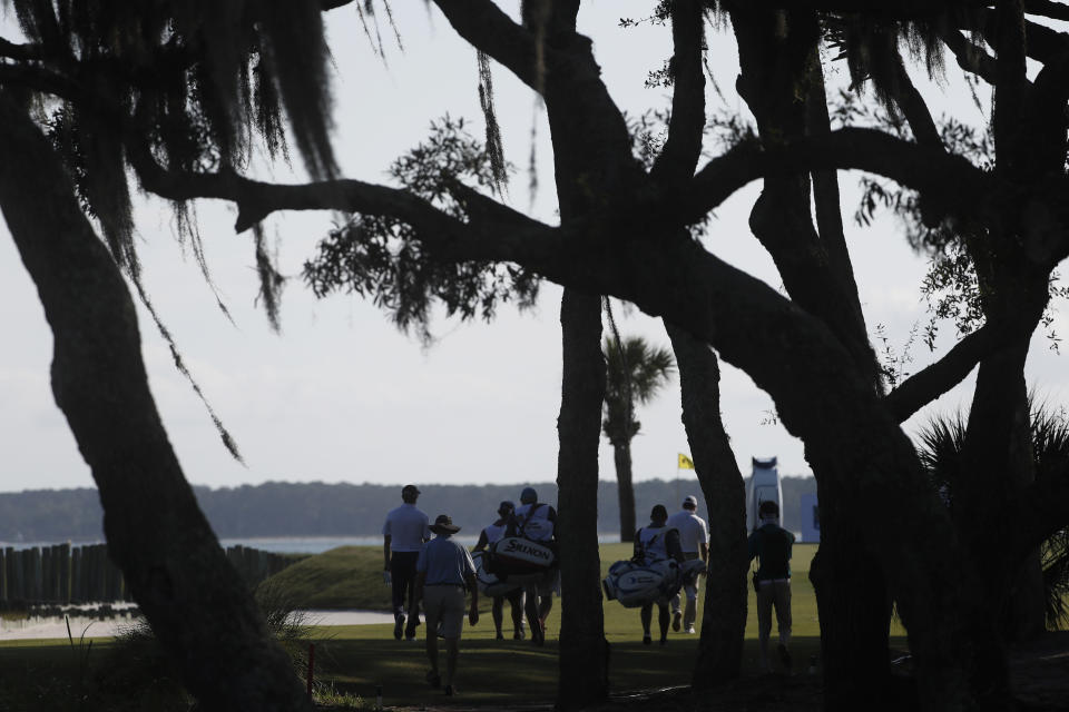 Ryan Palmer, Chez Reavie and Russell Knox and their caddies walk toward the 17th green during the first round of the RBC Heritage golf tournament Thursday, June 18, 2020, in Hilton Head Island, S.C. (AP Photo/Gerry Broome)