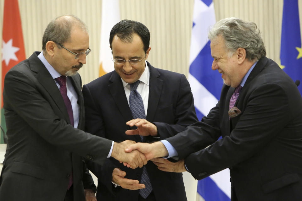 Cypriot foreign minister Nicos Christodoulides, center, shakes hands with Foreign minister of Jordan Ayman Safadi, left, and the Greek Alternate Minister of Foreign Affairs Georgios Katrougalos after their meeting at the presidential palace in Nicosia, Cyprus, Wednesday, Dec. 19, 2018. The three ministers are meeting in the Cypriot capital to explore ways of strengthening ties on fields as varied as education and entrepreneurship. (AP Photo/Petros Karadjias)