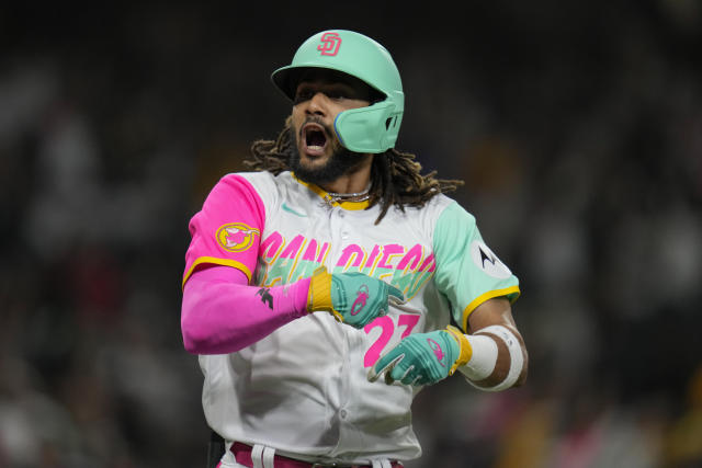 Fernando tatis jr in a padres jersey celebrating with a world