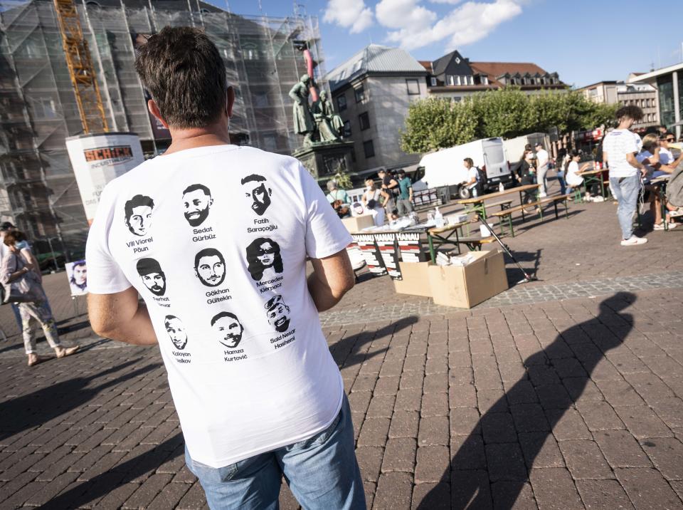 Ein Teilnehmer trägt ein T-Shirt mit den Gesichtern der Opfer (Bild: Frank Rumpenhorst/dpa)