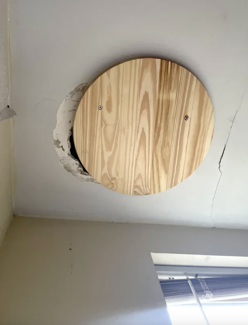 a piece of wood covering a hole in the ceiling