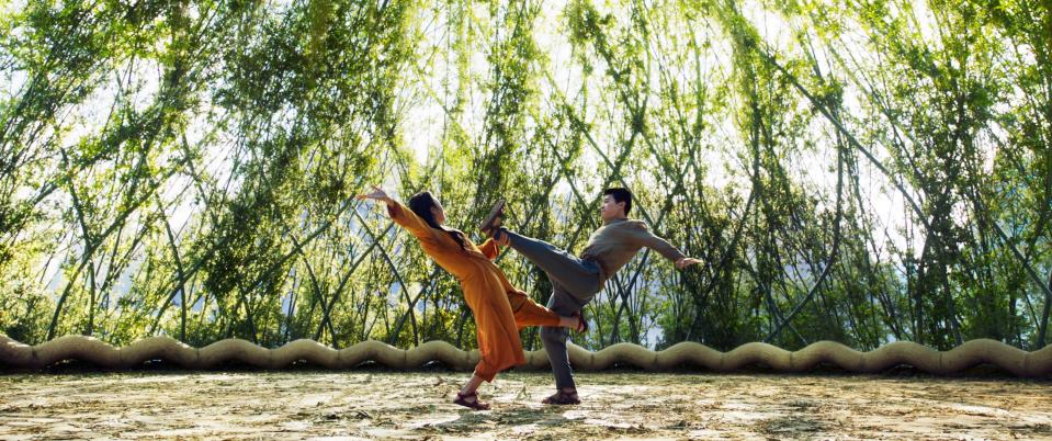 a wide shot of two of the characters fighting in a clearing