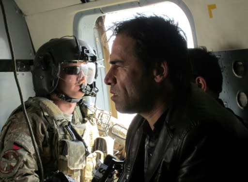 Shah Marai sits in a helicopter with a member of the International Security Assistance Force (ISAF) while on assignment in Afghanistan in 2013