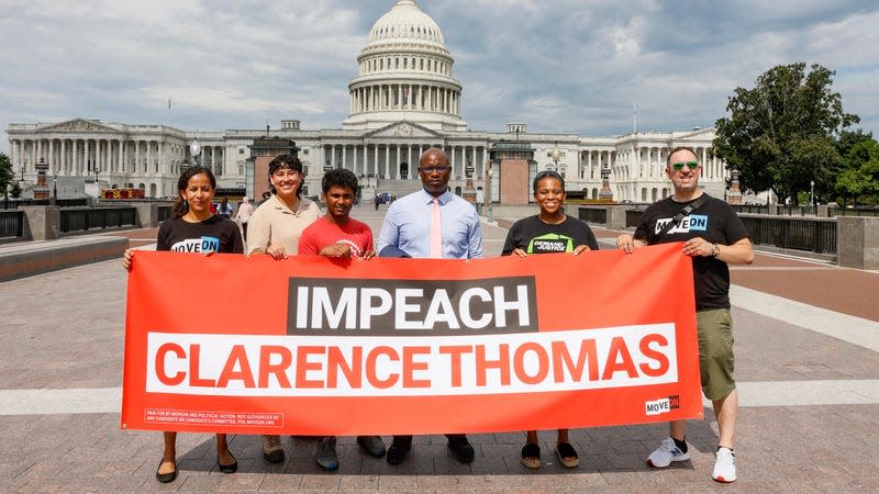 Executive Director of MoveOn.org Rahna Epting (far left), Rep. Jamaal Bowman (D-NY) (C), Tamara Brummer and Matthew Witten hold up an “Impeach Clarence Thomas” banner outside of the US Capitol after a demonstration where MoveOn.org delivered over 1 million signatures calling for Congress to immediately investigate and impeach Clarence Thomas at the US Supreme Court on July 28, 2022 in Washington, DC. 