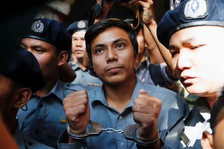 Detained Reuters journalist Kyaw Soe Oo is escorted by police after a court hearing in Yangon, Myanmar February 1, 2018. REUTERS/Jorge Silva