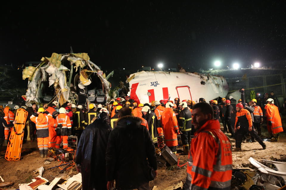 Rescue members and firefighters work around the wreckage of a plane after it skidded off the runway at Istanbul's Sabiha Gokcen Airport, in Istanbul, Wednesday, Feb. 5, 2020. The plane skidded off the runway, crashing into a field and breaking into pieces. Authorities said at least 52 people were injured, and passengers were seen evacuating through the cracks in the plane. (AP Photo/Emrah Gurel)