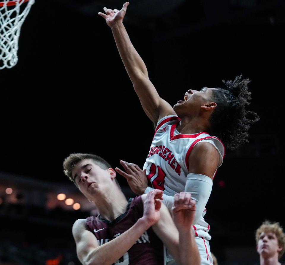 Roland-Story guard Isaiah Naylor (10) goes up for a layup against Western Christian guard Chandler Pollema (4) during the class 2A semifinals of the Iowa high school boys state basketball tournament.