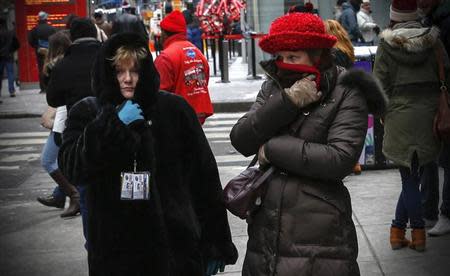 Two women bundle up against the cold in New York's Times Square, March 3, 2014. REUTERS/Mike Segar