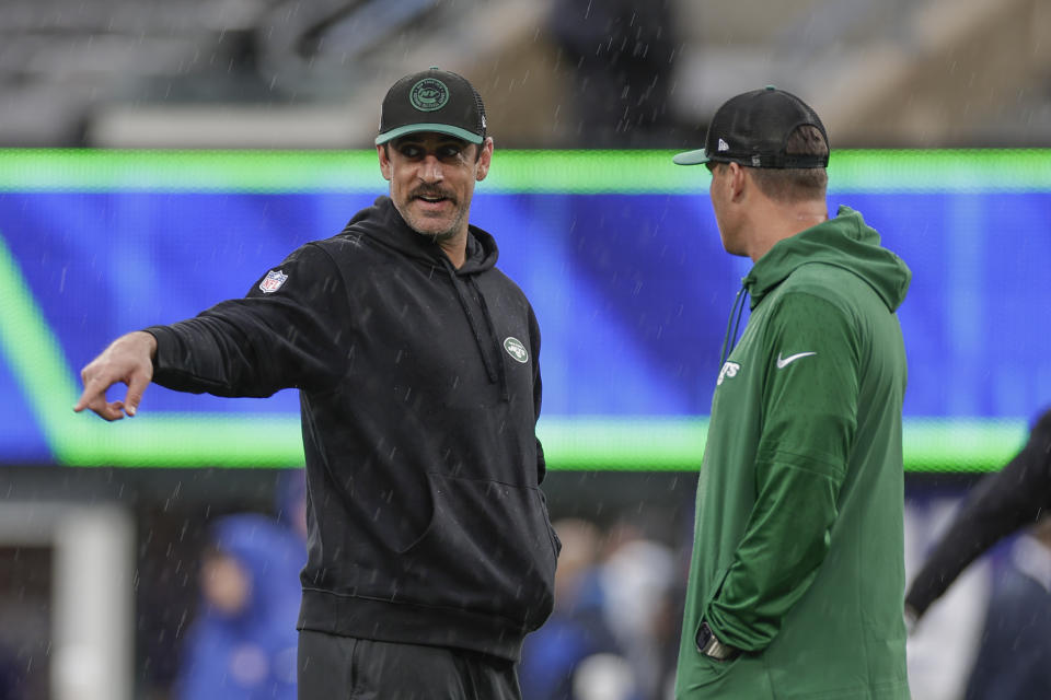 New York Jets quarterback Aaron Rodgers, left, and quarterback Zach Wilson, right, attend practice in the rain before an NFL football game against the New York Giants, Sunday, Oct. 29, 2023, in East Rutherford, N.J. (AP Photo/Adam Hunger)