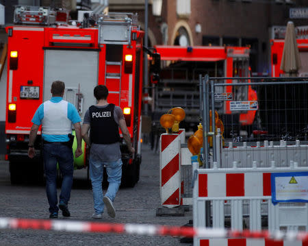 Police walk in a street near a place where a man drove a van into a group of people sitting outside a popular restaurant in the old city centre of Muenster, Germany, April 7, 2018. REUTERS/Leon Kuegeler