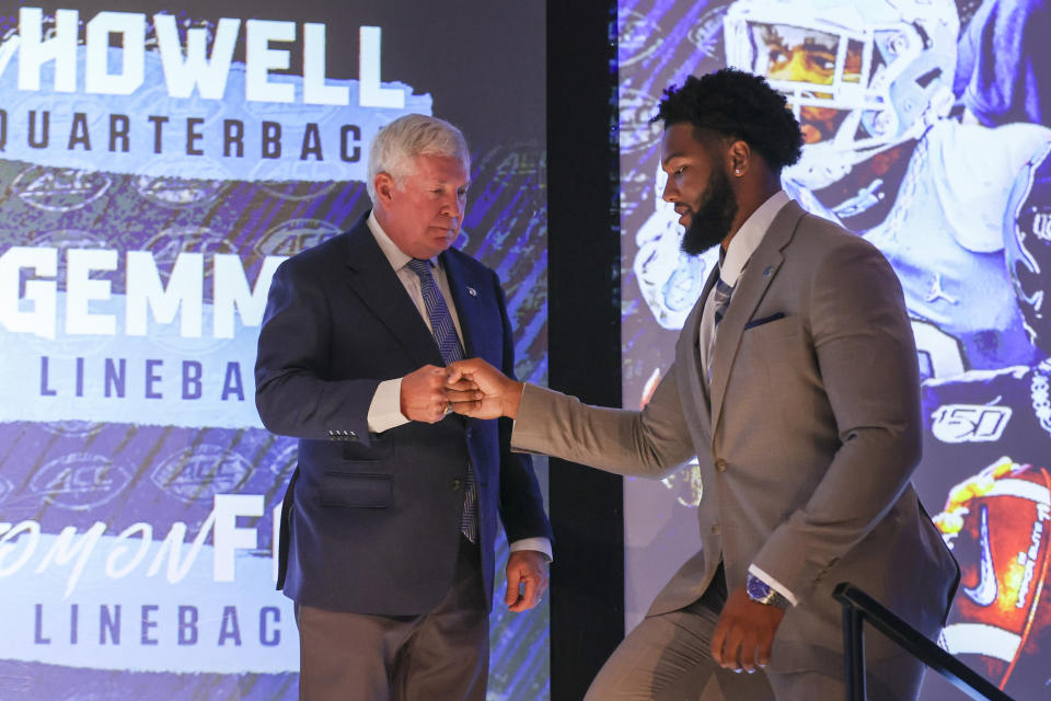 North Carolina head coach Mack Brown, left, fist bumps linebacker Tomon Fox during the NCAA college football Atlantic Coast Conference media days in Charlotte, N.C., Wednesday, July 21, 2021. (AP Photo/Nell Redmond)
