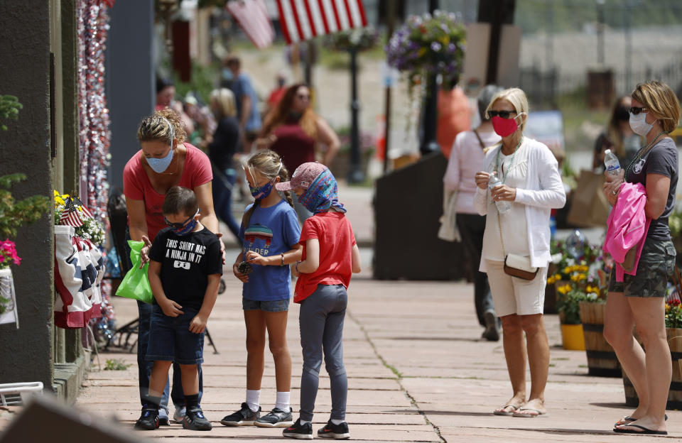 Visitors wear face coverings while walking around Monday, July 27, 2020, in the Mountain tourist town of Georgetown, Colo. (AP Photo/David Zalubowski)