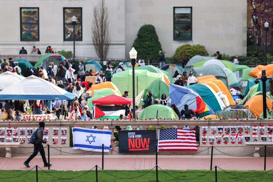 A man walks past Israeli and US flags alongside portraits of Israelis taken hostage by the militant Palestinian group Hamas in front of the pro-Palestinian encampment at Columbia University in New York on April 23, 2024.