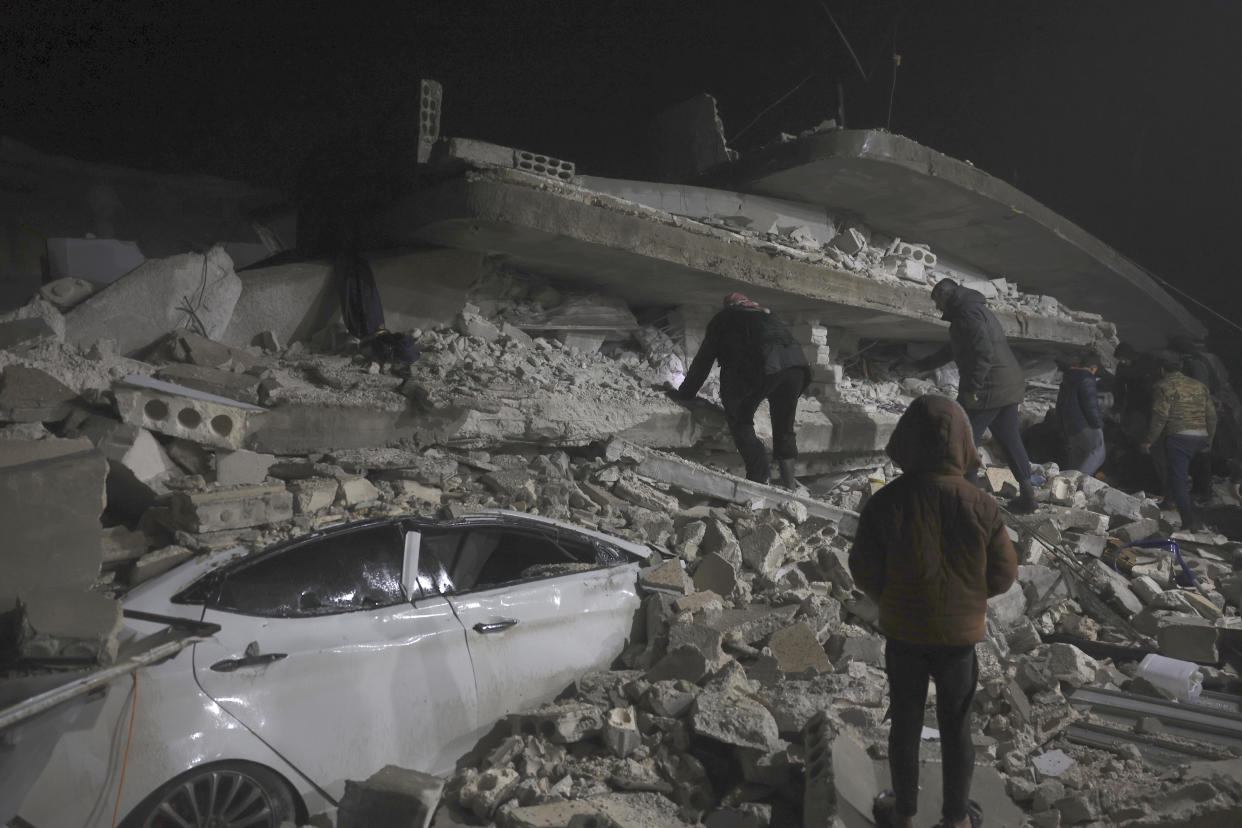 Syrian citizen search through the wreckage of a collapsed building, in Azmarin town, in Idlib province north Syria, Monday, Feb. 6, 2023. A powerful earthquake hit southeast Turkey and Syria early Monday, toppling buildings and sending panicked residents pouring outside in a cold winter night. (AP Photo/Ghaith Alsayed)
