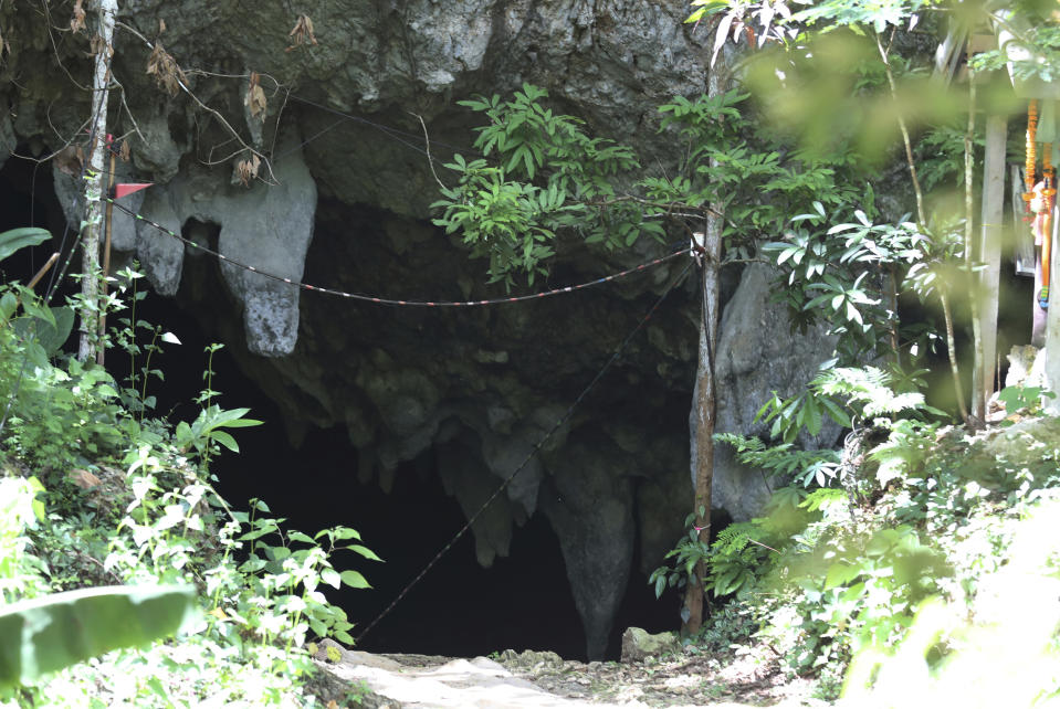 In this Saturday, June 22, 2019, photo, the entrance to Tham Luang Nang Non cave in the Mae Sai, Chiang Rai province, northern Thailand. Some of the 12 young Thai soccer players and their coach have marked the anniversary of their ordeal that saw them trapped in a flooded cave for two weeks with a commemorative marathon in northern Thailand. (AP Photo/Sakchai Lalit)