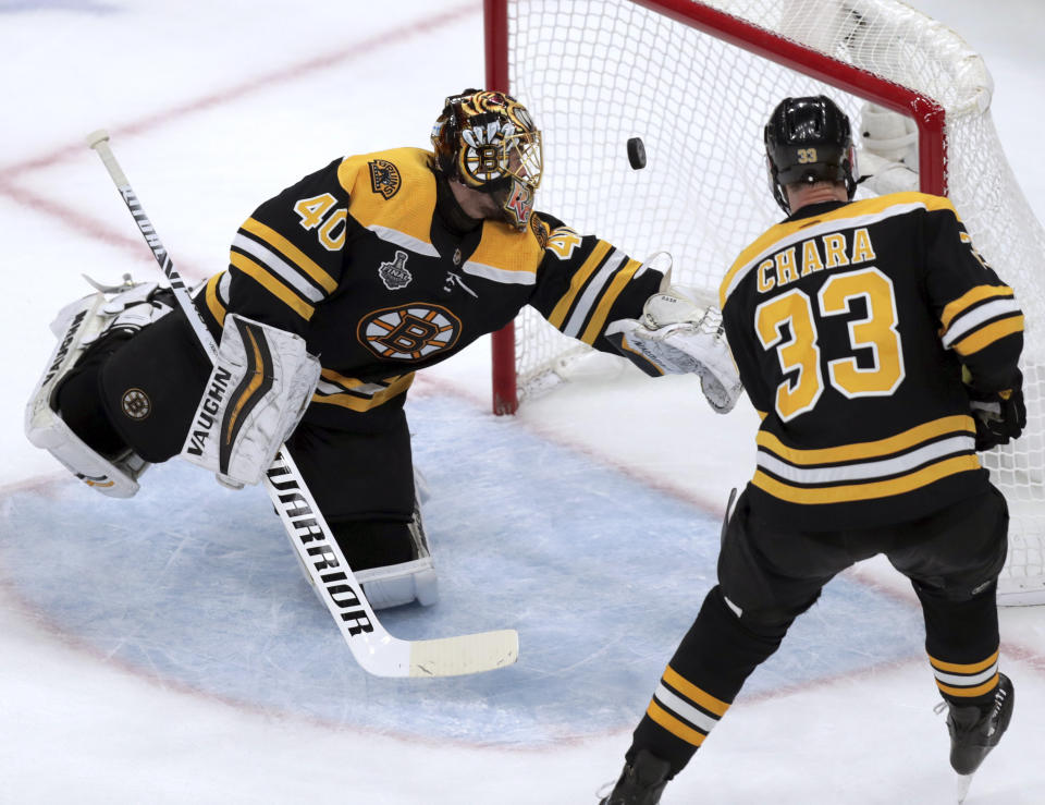 The puck bounces off the post behind Boston Bruins goaltender Tuukka Rask, left, of Finland, and Zdeno Chara, right, of Slovakia, during the second period in Game 7 of the NHL hockey Stanley Cup Final against the St. Louis Blues, Wednesday, June 12, 2019, in Boston. (AP Photo/Charles Krupa)