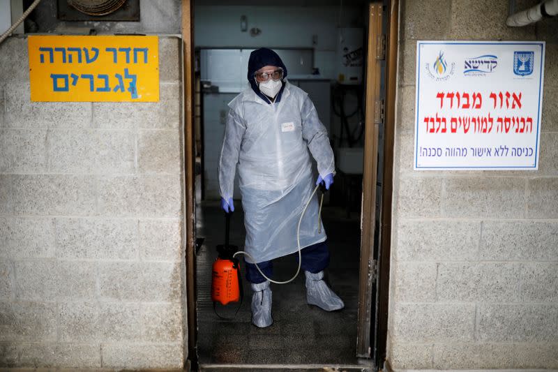 FILE PHOTO: Yakov Kurtz, who works for Chevra Kadisha, the main group overseeing Jewish burials in Israel, disinfects a room at a special centre that prepares bodies of Jews who died from the coronavirus disease (COVID-19), in Tel Aviv