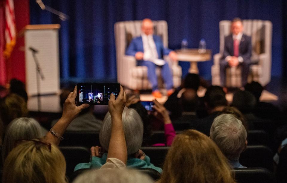 Attendees take photos as Speaker of the House Mike Johnson talks during the event hosted by the National Apostolic Christian Leadership Conference at Jackson Preparatory School in Flowood on Thursday.