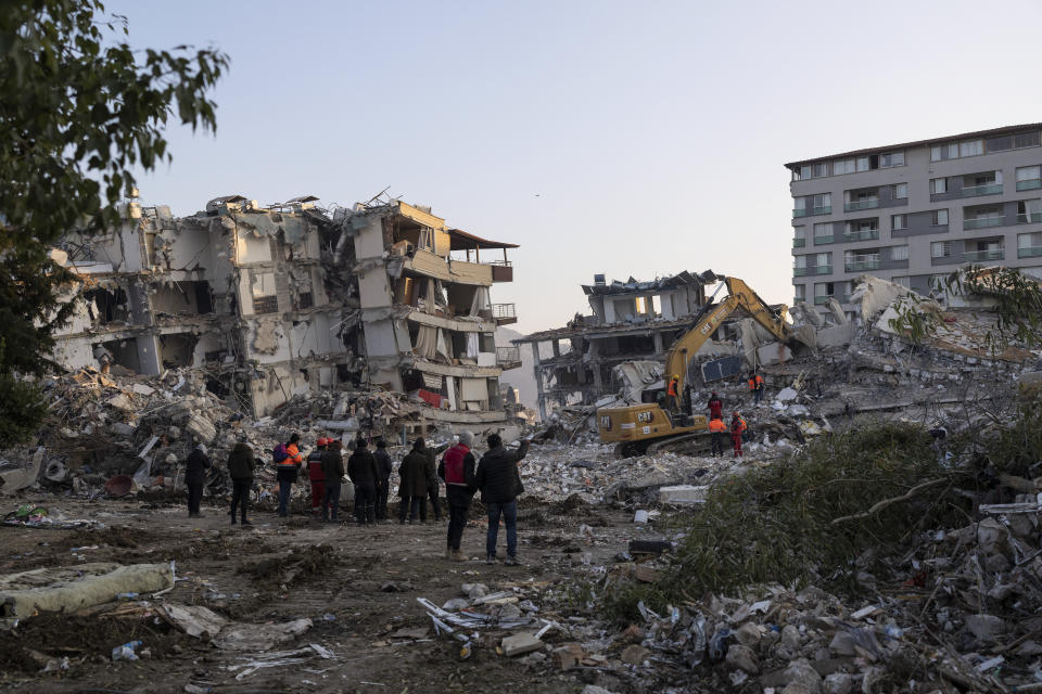 Rescue workers continue to clear rubble from collapsed building in Antakya, Turkey, Sunday, Feb. 12, 2023. Six days after two powerful earthquakes hours apart caused scores of buildings to collapse, killing thousands of people and leaving millions homeless, rescuers were still pulling unlikely survivors from the ruins. (AP Photo/Petros Giannakouris)