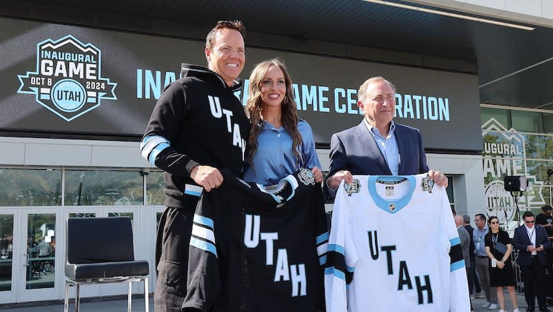 Utah Hockey Club owners Ryan and Ashley Smith and NHL Commissioner Gary Bettman hold jerseys at a press conference at  Delta Center plaza in Salt Lake City on Tuesday, Oct. 8, 2024.