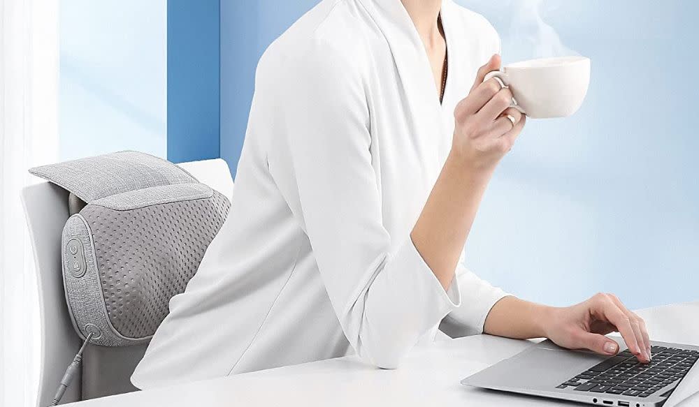 woman at desk with back massager