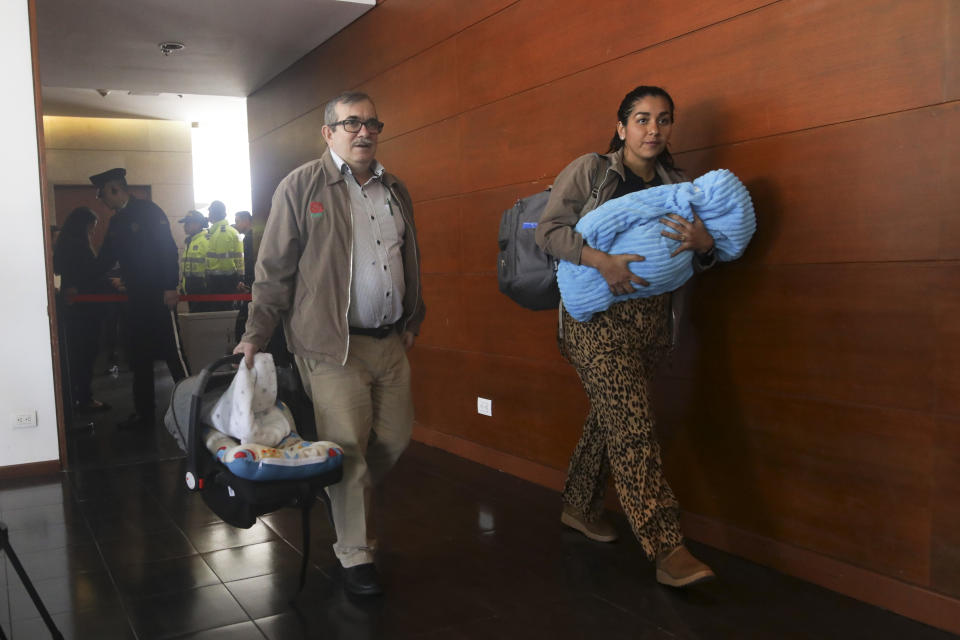 Accompanied by his wife Johana Castro and their child, former rebel leader commander Rodrigo Londono arrives to appear before Colombia's special peace tribunal to testify in an ongoing probe of their role in civilian kidnappings in Bogota, Colombia, Monday, Sept. 23, 2019. Londono, also know by his alias Timochenko, was the FARC's top military commander and now heads its legal political party. (AP Photo/Ivan Valencia)