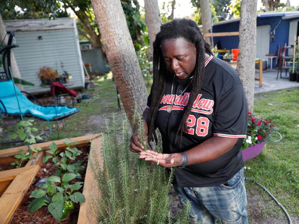 Corey "Goo" Paul wears a jersey and tends a plant in his garden.