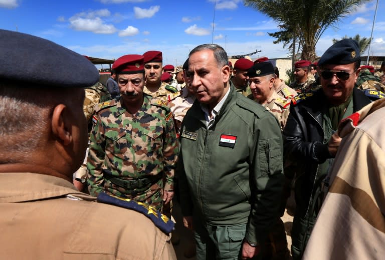 Iraqi Defence Minister Khaled Al-Obeidi (C) meets soldiers holding a position on the frontline during a visit on the outskirts of Makhmur, about 280 kilometres (175 miles) north of the capital Baghdad, on March 30, 2016