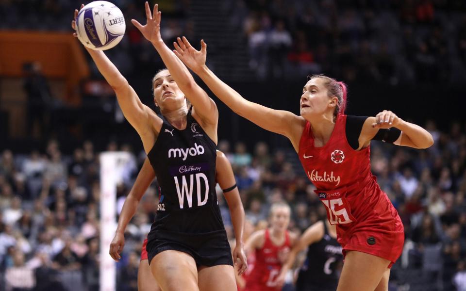 Karin Burger of New Zealand (left) takes a pass under pressure from England's George Fisher (right) - GETTY IMAGES