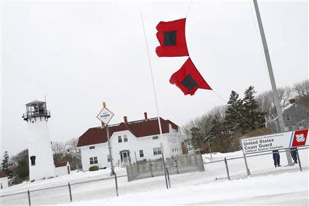 U.S. Coast Guard members lower the hurricane warning flags to downgrade the alert to storm warning at their station in Chatham, Massachusetts, March 26, 2014. REUTERS/Dominick Reuter