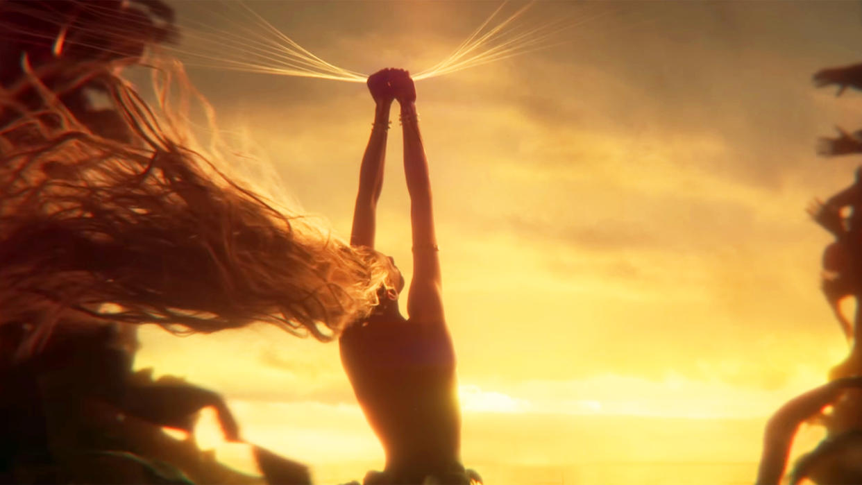  A still from the Elden Ring Shadow of the Erdtree story trailer of figure holding their arms up in front of a bright sky. 