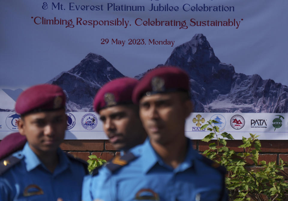 Policemen stand guard as a photograph of Mount Everest is seen behind during celebrations marking the 70 anniversary of the first ascent of Mount Everest in Kathmandu, Nepal, Monday, May 29, 2023. The 8,849-meter (29,032-foot) mountain peak was first scaled by New Zealander Edmund Hillary and his Sherpa guide Tenzing Norgay on May 29, 1953. (AP Photo/Niranjan Shrestha)